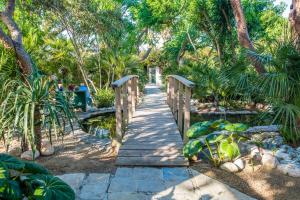 a wooden bridge over a pond in a garden at Casa de María in El Palmar