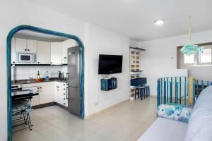 a living room with a kitchen with a refrigerator at Las Sales Duplex in Moya