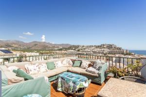 a couch on a balcony with a view of the ocean at Casa Mia in Almuñécar