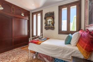 a bedroom with a bed and a mirror and windows at Casa Mia in Almuñécar