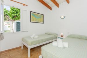 a bedroom with two beds and a window at Son Xoriguer 6 in Son Xoriguer +17 photos