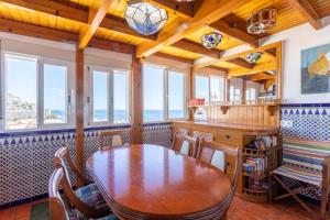 a dining room with a table and some windows at Casa Mia in Almuñécar