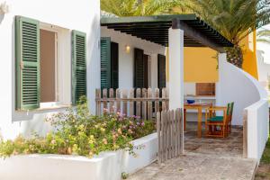a house with a porch with a table and some flowers at Son Xoriguer 6 in Son Xoriguer