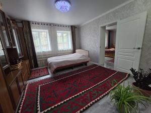 a bedroom with a bed and a large rug at Azis Hostel in Karatëbë