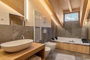 a bathroom with a sink and a tub and a toilet at Luxury Apartment Majon de Rita in Vigo di Fassa +18 photos