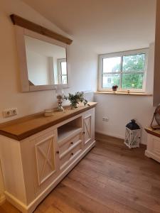 a bathroom with a vanity with a mirror at Rosenzauber Gipfelstürmer in Weißenstadt +30 photos