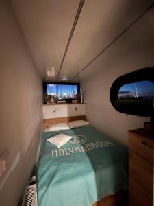 a small bed in a small room with a window at Hausboot mit Motorboot in Heiligenhafen