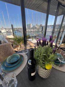 a table with a bottle of wine and flowers on it at Hausboot mit Motorboot in Heiligenhafen