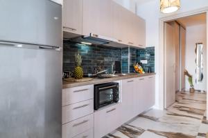 a kitchen with white cabinets and a sink at Oceanida Afrodite Lyxury Suite in Nikiana