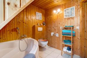a wooden bathroom with a tub and a toilet at Ferienwohnung Kurzentrum in Bad Lausick +14 photos