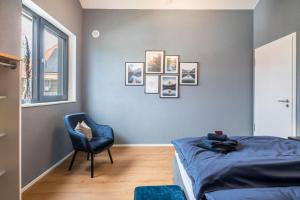 a bedroom with a bed and a cat sitting in a chair at Gold Haus in Weilheim