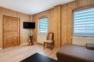 a living room with wood paneled walls and a television at Ferienwohnung Kurzentrum in Bad Lausick