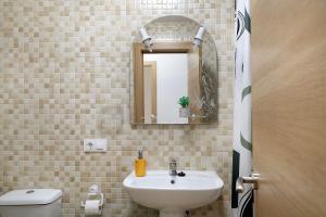 a bathroom with a sink and a mirror and a toilet at Campo Amor Alto in Arrecife +16 photos
