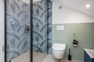 a bathroom with a shower with a toilet and a sink at Gold Haus in Weilheim +19 photos