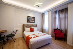 a hotel room with a bed and a red chair at 1826 Heritage Suites in Taksim