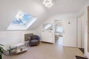 a living room with a vaulted ceiling with a skylight at Ferienwohnung Rosengarten in Mössingen +28 photos