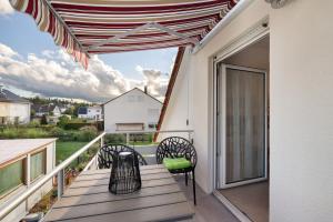 a balcony with two chairs and a table on a porch at Ferienwohnung Rosengarten in Mössingen