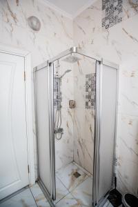 a shower with a glass door in a bathroom at 1826 Heritage Suites in Taksim