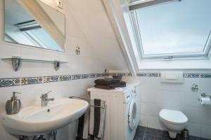 a bathroom with a sink and a toilet and a mirror at Straub in Meckenbeuren
