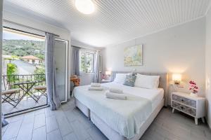 a bedroom with a large bed and a balcony at Casa Di Babis in Gaios