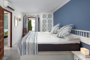 a bedroom with a large bed with striped pillows at Dalias Nerja in Nerja