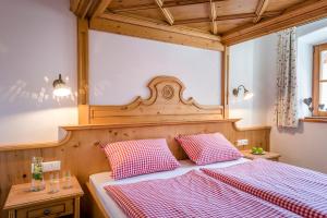 a bedroom with a bed with a red and white checkered blanket at Beim Paulfischer - Eckbankerl in Chieming