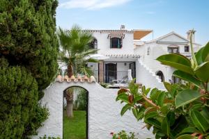 a white house with an archway in the yard at Dalias Nerja in Nerja