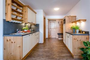 a kitchen with white cabinets and wooden flooring at Beim Paulfischer - Eckbankerl in Chieming