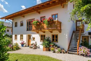 a house with a balcony with flowers on it at Beim Paulfischer - Eckbankerl in Chieming