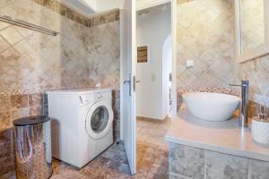 a bathroom with a washing machine and a sink at Villa Belvedere Verde in Lefkada