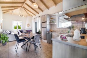 a kitchen and dining room with a table and chairs at Villa Belvedere Verde in Lefkada