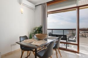 a dining room with a table and chairs and a balcony at Primera linea vistas panoramicas in Torremolinos
