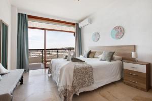 a bedroom with a large bed and a large window at Primera linea vistas panoramicas in Torremolinos +30 photos