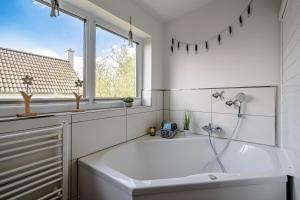 a white bathroom with a sink and a window at An der Ostsee by Seeblick Ferien in Kappeln +28 photos