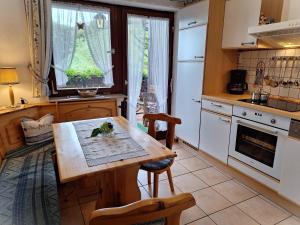 a kitchen with a wooden table and chairs and a window at Christianshof in Oppenau