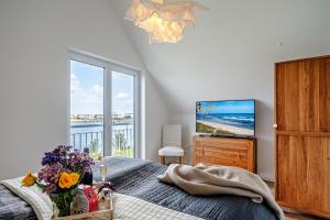 a bedroom with a bed with flowers and a television at An der Ostsee by Seeblick Ferien in Kappeln