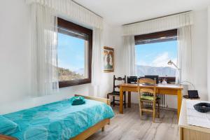 a bedroom with a bed and a desk and a table at Appartamento Gran Vista in Premeno