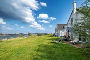 a house with a grass yard next to a river at An der Ostsee by Seeblick Ferien in Kappeln