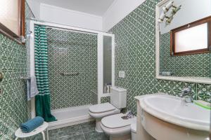 a bathroom with a toilet and a sink and a shower at Casa Tangerina in Tavira +13 photos