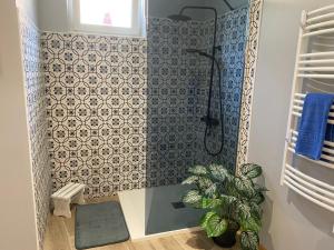 a bathroom with a shower with a tile wall at La petite Cocotte in Marcheseuil +7 photos