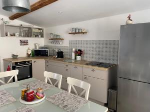 a kitchen with a table and a refrigerator at La petite Cocotte in Marcheseuil