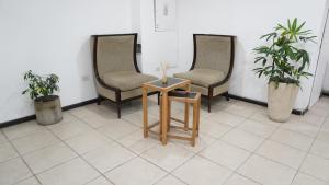 two chairs and a table in a room with plants at HOTEL APOLO NEUQUEN in Neuquén +22 photos