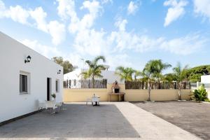 a courtyard with a white building and palm trees at Villa Montenmedio - Juande in El Soto