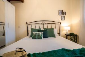 a bedroom with a large bed with green pillows at Chelubirdi in Villasimius