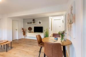 a living room with a table and chairs and a television at Ferienwohnung-Bachlauf-Eslohe in Eslohe