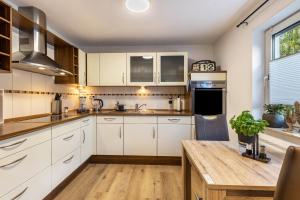a kitchen with white cabinets and a wooden table at Ferienwohnung-Bachlauf-Eslohe in Eslohe