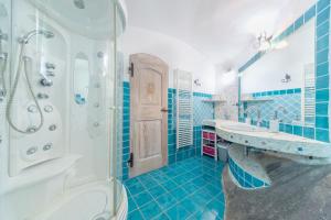 a blue and white bathroom with two sinks and a shower at Villa Rosa in Porto Rotondo +26 photos