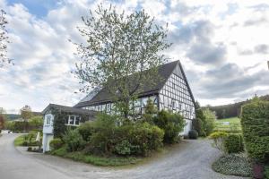 a black and white house with a tree in front of it at Ferienwohnung-Bachlauf-Eslohe in Eslohe