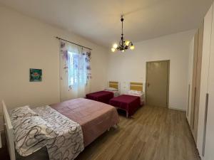 a bedroom with two beds and a chandelier at Adamo Flat in Bisciano
