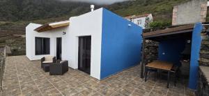 a blue and white house with a table and chairs at Los Almendr2s in Frontera